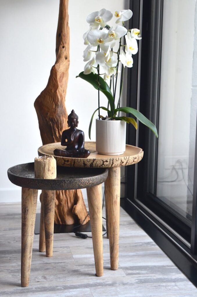 Stylish interior featuring a Buddha statue, white orchids, and rustic decor.